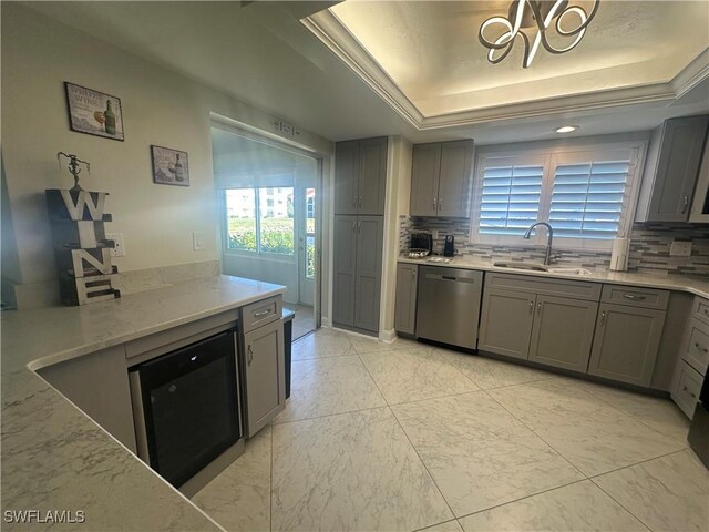 kitchen featuring backsplash, gray cabinetry, a sink, and dishwasher