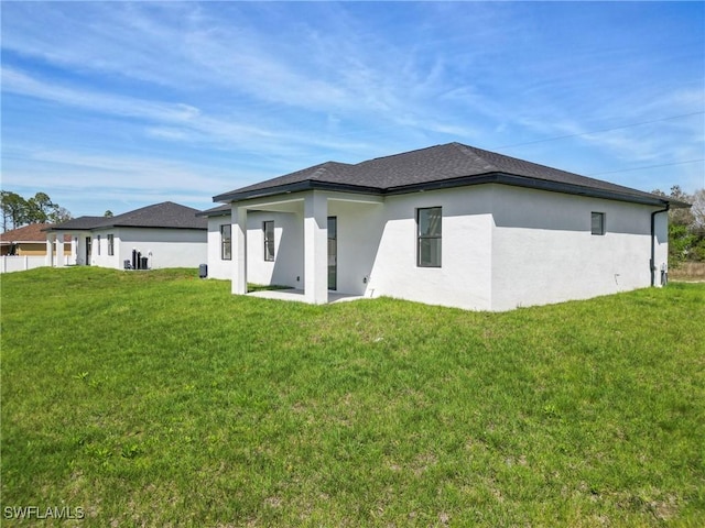 back of property featuring a yard and stucco siding