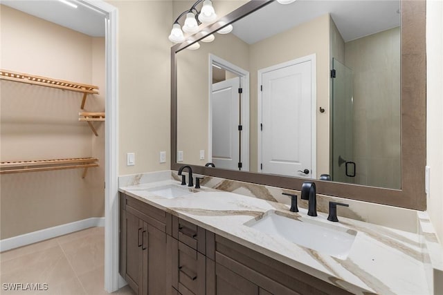 7282 Saona Ct, Naples, FL 34113 - full bathroom featuring double vanity, a spacious closet, tile patterned flooring, an enclosed shower, and baseboards