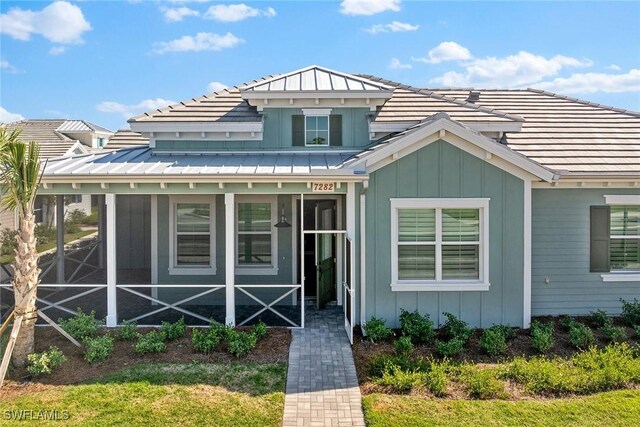 7282 Saona Ct, Naples, FL 34113 - view of front of property featuring board and batten siding, a standing seam roof, and metal roof