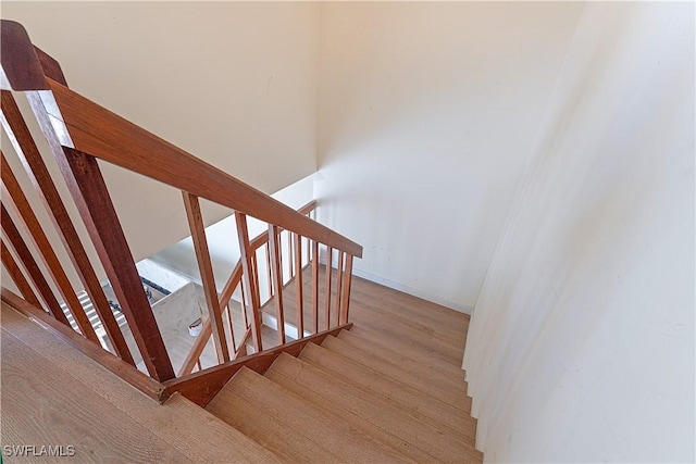 stairway with baseboards and wood finished floors