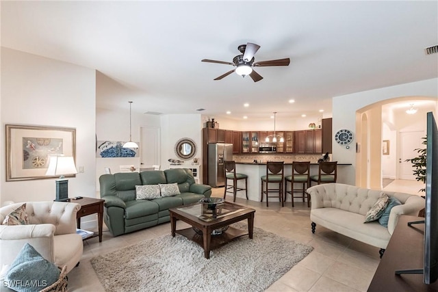 living area featuring recessed lighting, light tile patterned flooring, arched walkways, visible vents, and ceiling fan