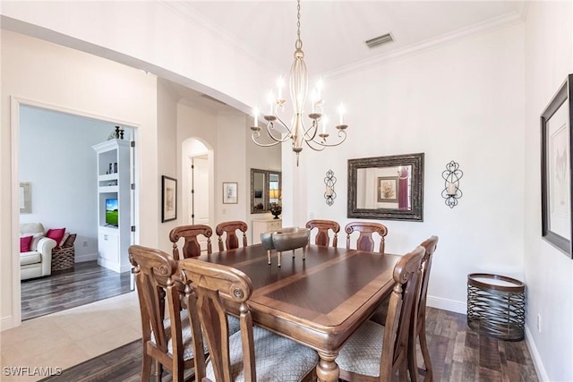 dining room featuring an inviting chandelier, ornamental molding, baseboards, dark wood finished floors, and arched walkways