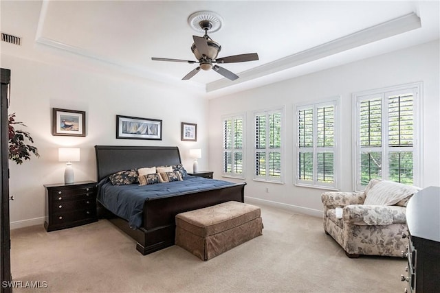 bedroom with a tray ceiling, baseboards, ceiling fan, visible vents, and light carpet