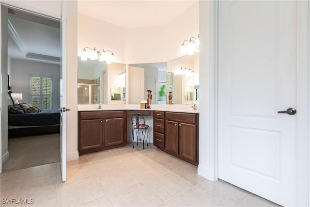ensuite bathroom featuring a shower with door, double vanity, connected bathroom, and a sink