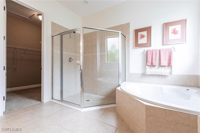bathroom with a spacious closet, tile patterned floors, a stall shower, and a bath