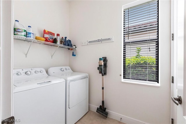 laundry area with light tile patterned floors, washing machine and dryer, baseboards, and laundry area