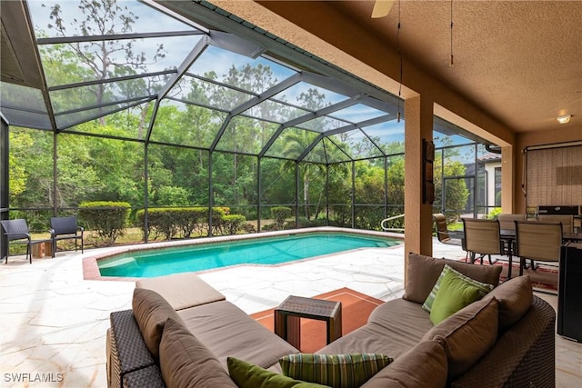 outdoor pool with a lanai, an outdoor living space, and a patio