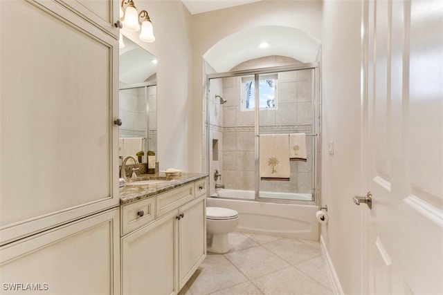 full bathroom featuring tile patterned flooring, vanity, toilet, baseboards, and enclosed tub / shower combo
