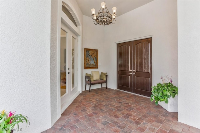 entryway featuring french doors and a notable chandelier