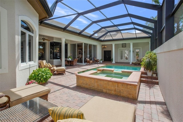 exterior space featuring a pool with connected hot tub, glass enclosure, ceiling fan, and a patio area