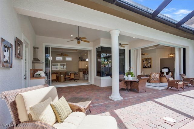 view of patio featuring glass enclosure and a ceiling fan