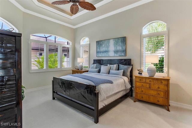 bedroom with baseboards, crown molding, and light colored carpet