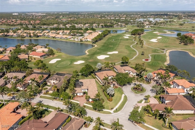 drone / aerial view with a residential view, golf course view, and a water view