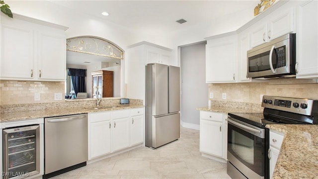 5705 Heron Ln Unit 801, Naples, FL 34110 - kitchen with a sink, stainless steel appliances, tasteful backsplash, visible vents, and beverage cooler
