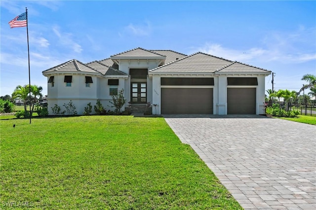 16768 San Edmundo Rd, Punta Gorda, FL 33955 - prairie-style house with french doors, an attached garage, stucco siding, decorative driveway, and a tiled roof