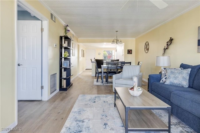 2445 W Gulf Dr Unit 21E, Sanibel, FL 33957 - living area with visible vents, crown molding, baseboards, ceiling fan with notable chandelier, and wood finished floors