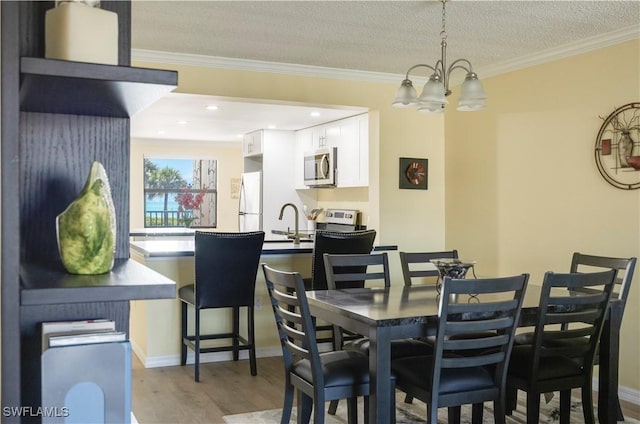 2445 W Gulf Dr Unit 21E, Sanibel, FL 33957 - dining space with baseboards, wood finished floors, an inviting chandelier, and ornamental molding