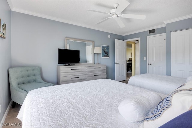 2445 W Gulf Dr Unit 21E, Sanibel, FL 33957 - bedroom with visible vents, crown molding, baseboards, and wood finished floors