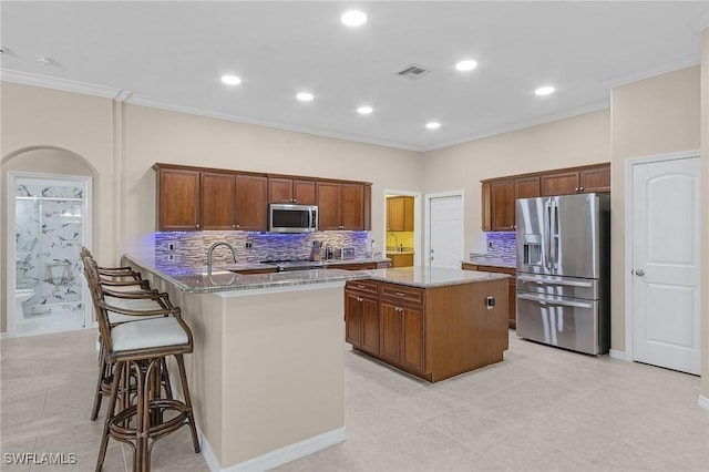 13773 Ox Bow Rd, Fort Myers, FL 33905 - kitchen featuring light stone countertops, visible vents, a peninsula, stainless steel appliances, and a center island