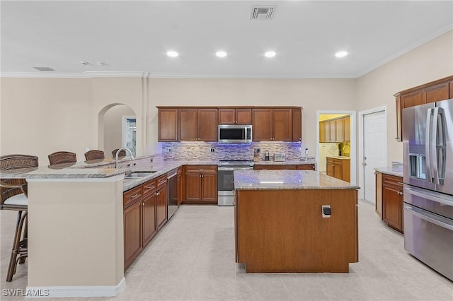 13773 Ox Bow Rd, Fort Myers, FL 33905 - kitchen featuring a center island, a breakfast bar, appliances with stainless steel finishes, arched walkways, and a sink