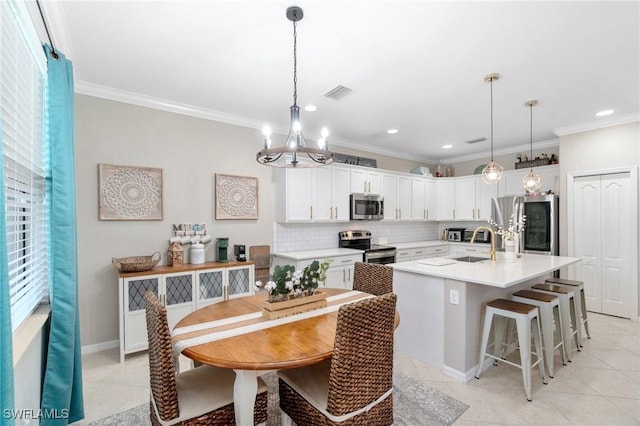 13570 San Georgio Dr, Estero, FL 33928 - kitchen featuring a chandelier, ornamental molding, stainless steel appliances, tasteful backsplash, and a sink