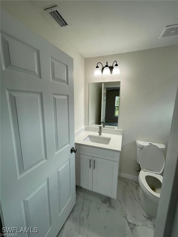 4748/4750 30th St SW, Lehigh Acres, FL 33973 - half bathroom with vanity, toilet, baseboards, and marble look tiles