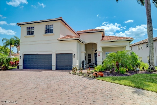 1696 Sarazen Pl, Naples, FL 34120 - mediterranean / spanish-style home featuring a tiled roof, stucco siding, and decorative driveway