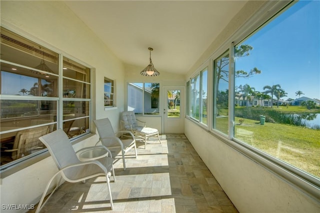 sunroom featuring a water view