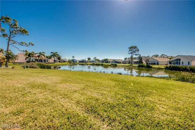 view of yard featuring a residential view and a water view