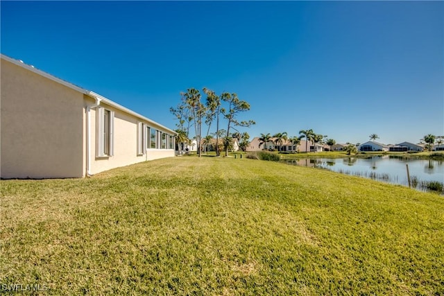 view of yard featuring a residential view and a water view