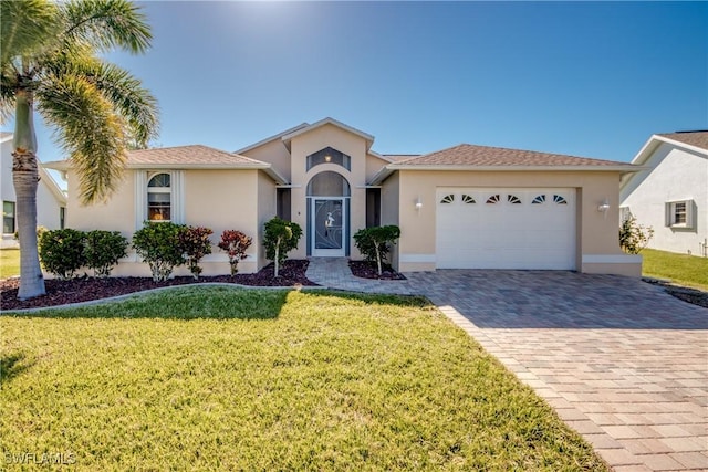 view of front of house with a front lawn, decorative driveway, stucco siding, and an attached garage