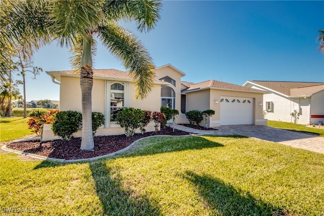 view of front of house with a front yard, decorative driveway, stucco siding, and an attached garage