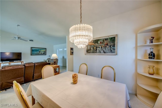 dining space with built in features, ceiling fan with notable chandelier, and light colored carpet