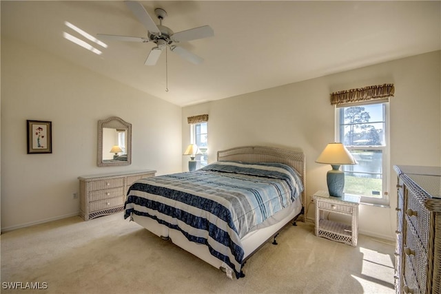 bedroom featuring baseboards, lofted ceiling, a ceiling fan, and light carpet