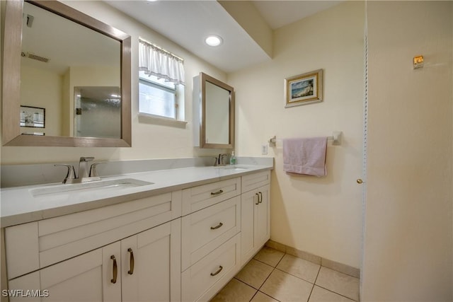 full bath featuring tile patterned floors, visible vents, double vanity, and a sink