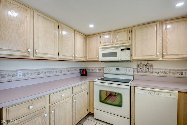 kitchen featuring light countertops, light brown cabinetry, and white appliances