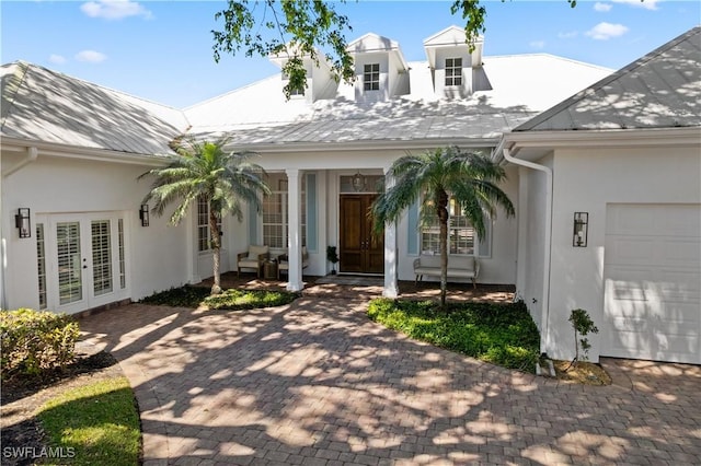 505 Harbour Dr, Naples, FL 34103 - doorway to property with french doors, a garage, stucco siding, and covered porch