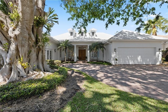 505 Harbour Dr, Naples, FL 34103 - view of front of house featuring french doors, a garage, stucco siding, and decorative driveway