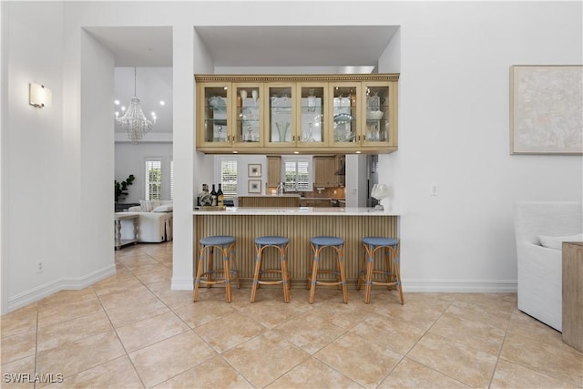 505 Harbour Dr, Naples, FL 34103 - bar featuring a chandelier, wall chimney exhaust hood, baseboards, and light tile patterned flooring