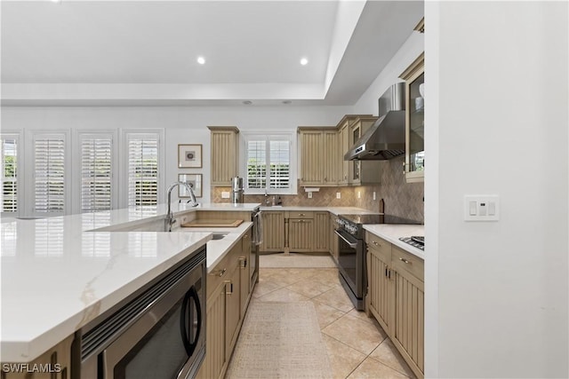 505 Harbour Dr, Naples, FL 34103 - kitchen featuring stainless steel microwave, wall chimney range hood, light tile patterned floors, electric range, and decorative backsplash