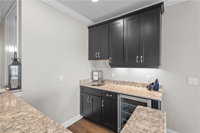 indoor wet bar with crown molding, baseboards, wine cooler, and wood finished floors