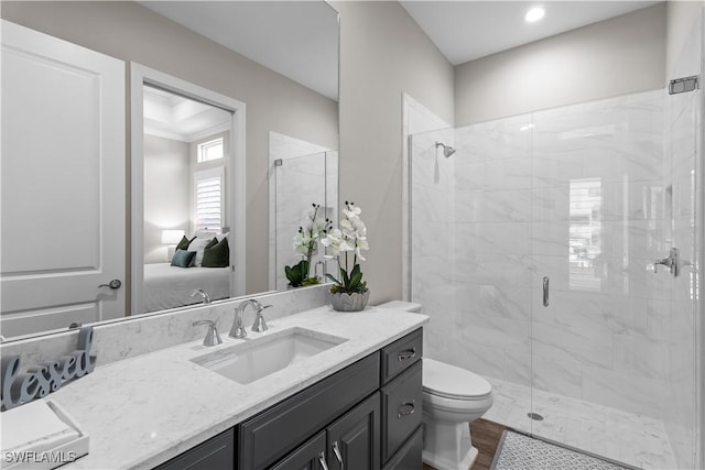 bathroom with a stall shower, toilet, vanity, and wood finished floors