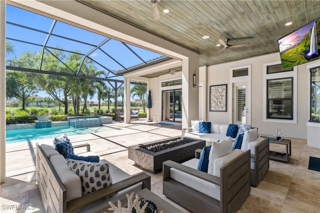 view of patio featuring a ceiling fan, an outdoor living space with a fire pit, a pool with connected hot tub, and a lanai