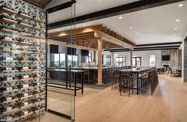 wine cellar featuring wood finished floors, recessed lighting, and beamed ceiling