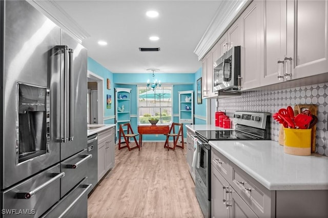 62 Lanai Cir Unit 62, Naples, FL 34112 - kitchen featuring appliances with stainless steel finishes, light countertops, light wood-style flooring, a chandelier, and recessed lighting