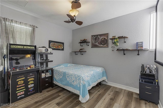 bedroom with baseboards, wood finished floors, and a ceiling fan
