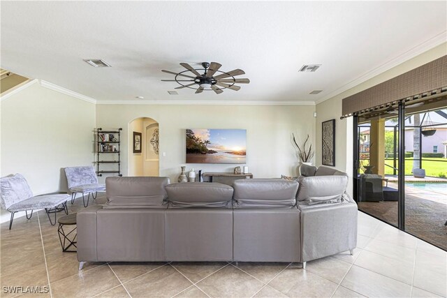 living room featuring arched walkways, ornamental molding, visible vents, and ceiling fan