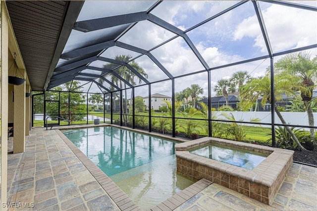 view of swimming pool featuring glass enclosure, fence, a pool with connected hot tub, and a patio area
