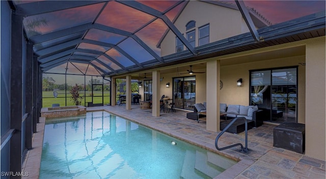 outdoor pool with an in ground hot tub, a patio area, a ceiling fan, an outdoor hangout area, and a lanai